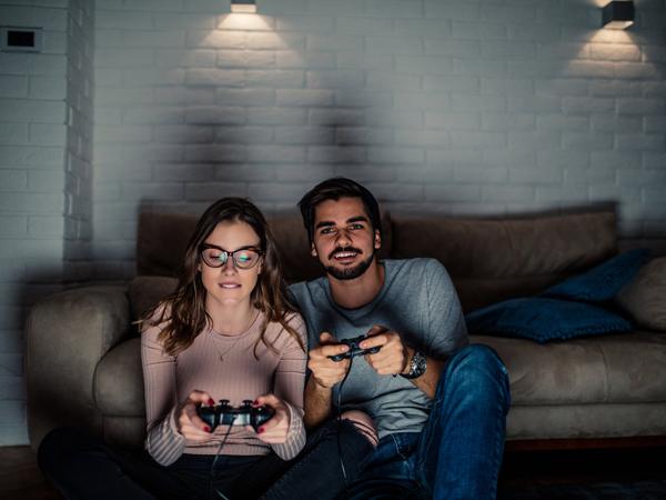 A couple on a sofa playing a video game together with controllers